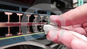 One male IT engineer working in a data center with rows of server racks and super computers.