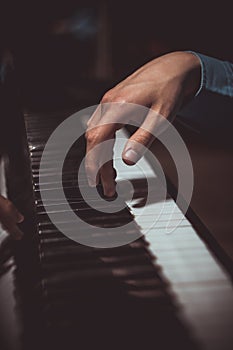 One male hand on the piano. The palm lies on the keys and plays the keyboard instrument in the music school. student learns to