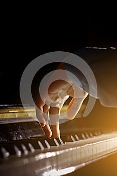 One male hand on the piano. The palm lies on the keys and plays the keyboard instrument in the music school. student learns to