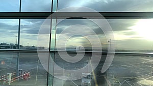 One man in a bright building of an airport lounge waiting at the window and looking at the street, travel concept