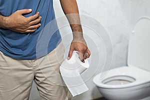 One man has diarrhea He then went to the bathroom to take numbers two. In his hand he had tissue paper to wash and clean photo