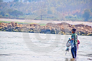 One man is preparing to throwing a net to catching fish in the Mekong Rive in dry season, The way of life of Thai people in