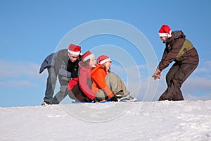 One man pull two girls on sled