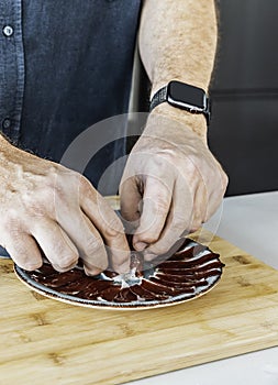 One man serving slices of iberic ham on a plate. Spanish jamon