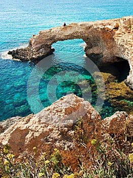 One man sitting on a natural landmark Love Bridge