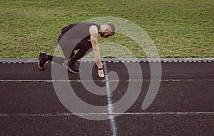 One man on the start line awaits the start of the sprint. stadium, rubber track. athletics competitions. Track and field runner in