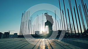 One man uses a drill on a construction site.