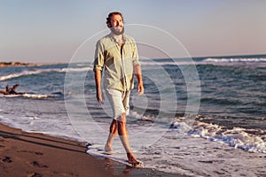 Man walking on the beach on sunset.