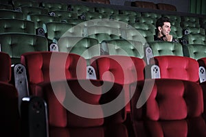 One man watches cinema alone, separate from other audiences at empty theaters.