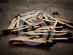 One Matchstick burning on top of many exhausted matchsticks