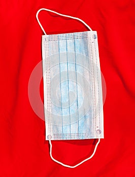 One medical mask for one-use is on a red background