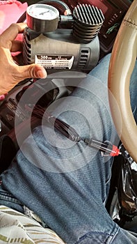 One men in her car holding a compresser in her heand photo
