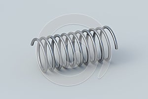 One metallic spring on gray background. Flexibility wire. Twisted steel coils. Auto parts. Accessories for automotive maintenance.