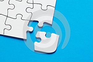 One missing puzzle piece on blue background with copy space. Connection or separation concept