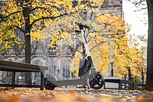 One modern green electric scooter sharing parked at Magdeburg city dom square alley street. Self-service street