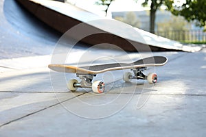 One modern skateboard with black griptape in skatepark