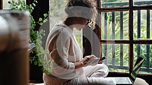 One modern woman sitting at home on the floor using cellphone to send message. Modern female people enjoying app and online