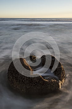 One of the Moeraki Boulders at sunrise with a colourful sky, New Zealand