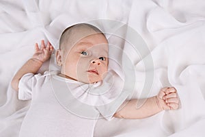 One month old baby boy lying on blanket