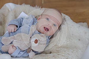 One month old baby boy lying with teddy bear