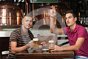 One more beer please! Two friends drinking beer at the pub while