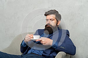 One more relaxing cup of tea. Manager man drink coffee relaxing in armchair. Rest break at work