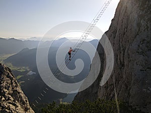 One of the most famous via ferratas in the world. The Intersport via ferrata on Donnerkogel in Austria. A man climbs to the other