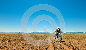 One Motorbiker driving on dirt road through grasland desert. Motorcycle Adventure in Namib, Namibia.