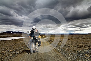 One Motorbiker Man driving on a gravel road in Kaldidalur desert. Motorcycle Adventure in Iceland.