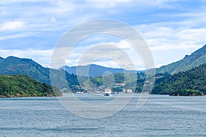 One of New zealand`s inter-island ferry leaving picturesque landscape and small township behind