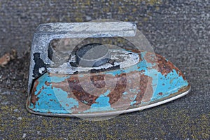 one old blue electric iron toy in brown rust