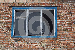 Old broken window on brown brick wall of a house