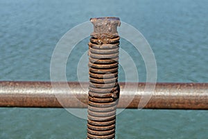 One old brown long iron pin in rust with thread