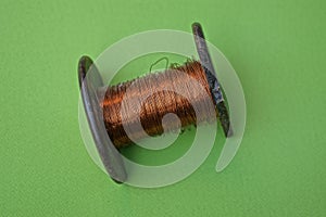 One old brown spool with a skein of red copper wire