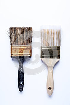 One old dirty paintbrush side by side with new clean paintbrush