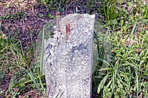 One old gray broken concrete pillar with rusty iron brown rebar