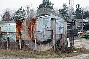 One old gray metal trailer booth in brown rust with an open door