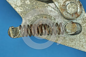 one old iron brown rusty spring on a gray metal structure