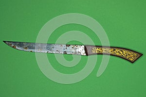 One old long knife with a gray rusty blade and a red yellow handle