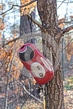 one old red mini mobile tape recorder with radio and black speaker