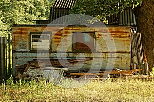 Old rusty trailer with windows in the grass on the street