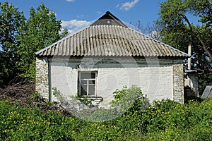 One old white rural brick house with a window