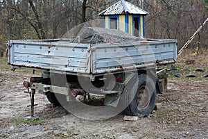 One open gray metal trailer with black wheels