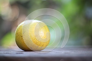 One orange on the wooden background behind