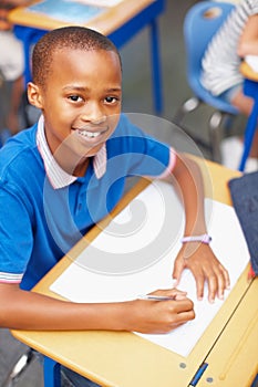 One of our brightest students, working hard as usual. Topview of a confident young african-american school pupil smiling