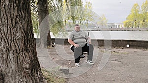 One overweight man in the park exercising. Male large Caucasian man working outdoors. Weight loss