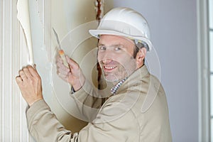 one painter worker peeling off wallpaper