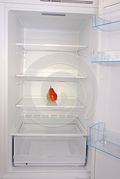 One pear in open empty refrigerator.