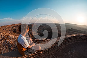 One person looking at the Fish River Canyon, scenic travel destination in Southern Namibia. Expansive view at sunset. Wanderlust t