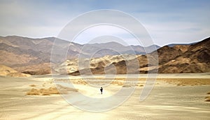 One person standing, admiring majestic mountain range at sunset generated by AI